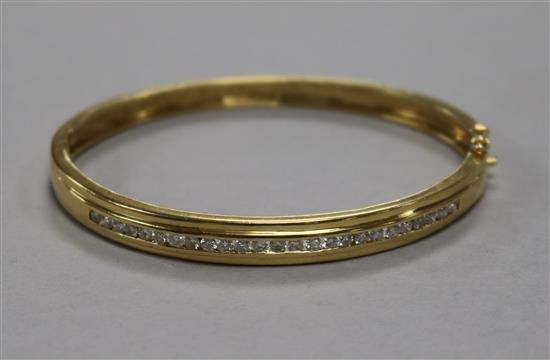 A modern 18ct gold and channel set diamond hinged bangle, gross 16.6 grams.